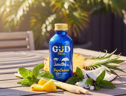 Herbal energy drinks displayed outdoors with fresh herbs